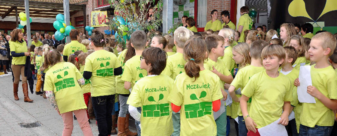 schoolkinderen op de speeplaats terwijl ze allemaal een limoengroen t-shirts van de school dragen